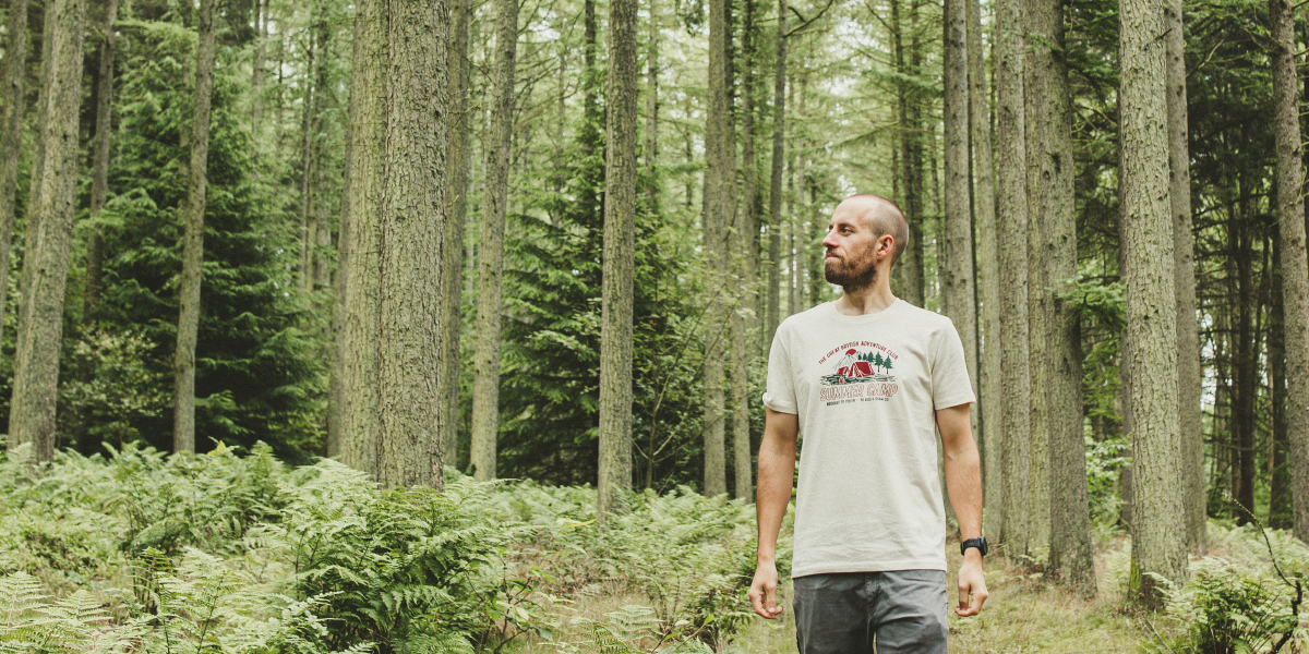 Man in forest wearing summer camp t-shirt